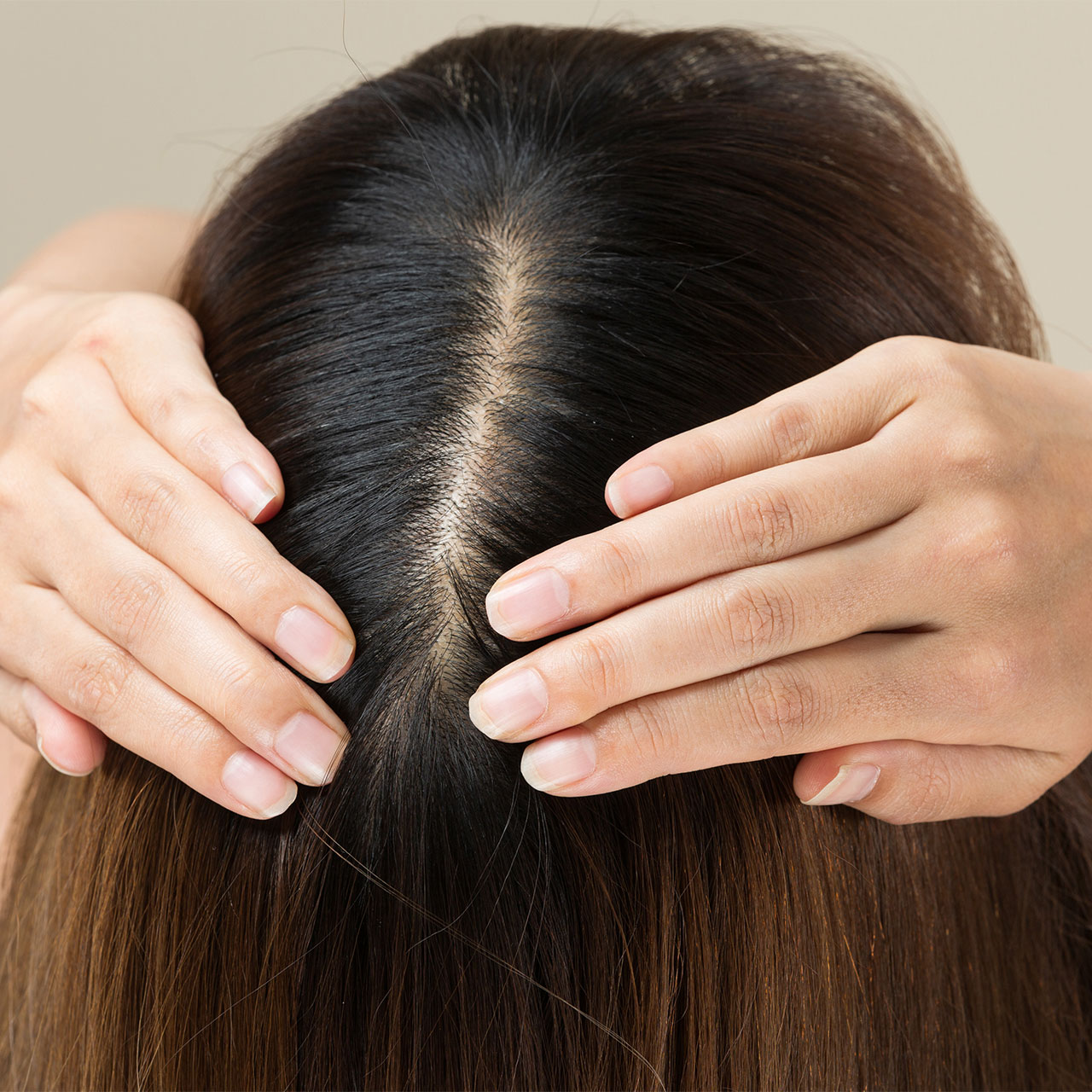 woman showing off her healthy hair scalp 1 5 Expert-Approved Hair Oils And Serums That Can Transform Fine, Weak Hair Into Thicker Locks