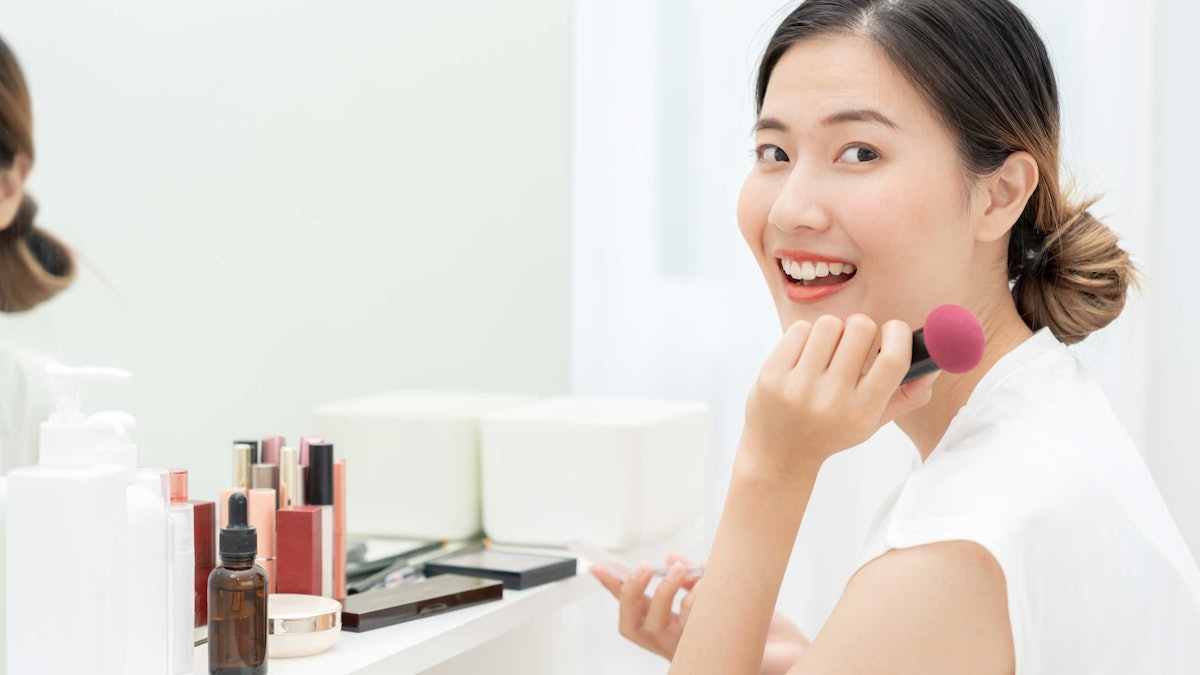 happy Asian woman seated at makeup mirror cosmetics on shelf smiling at cameraAdobeStock 752674266.670b0270a0f49 Top 3 Trends, Claims Projected for Asia-Pacific Beauty in 2025