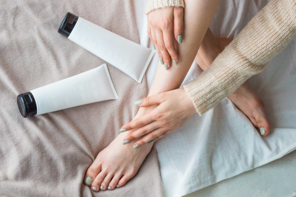 woman legs crossed on bed tubes of creams AdobeStock 245300454.670019bd505e3 Making Heads or Tails of the Thriving All-body Deodorant Market