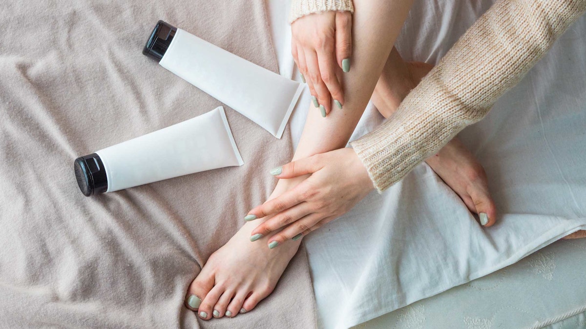 woman legs crossed on bed tubes of creams AdobeStock 245300454.670019bd505e3 Making Heads or Tails of the Thriving All-body Deodorant Market